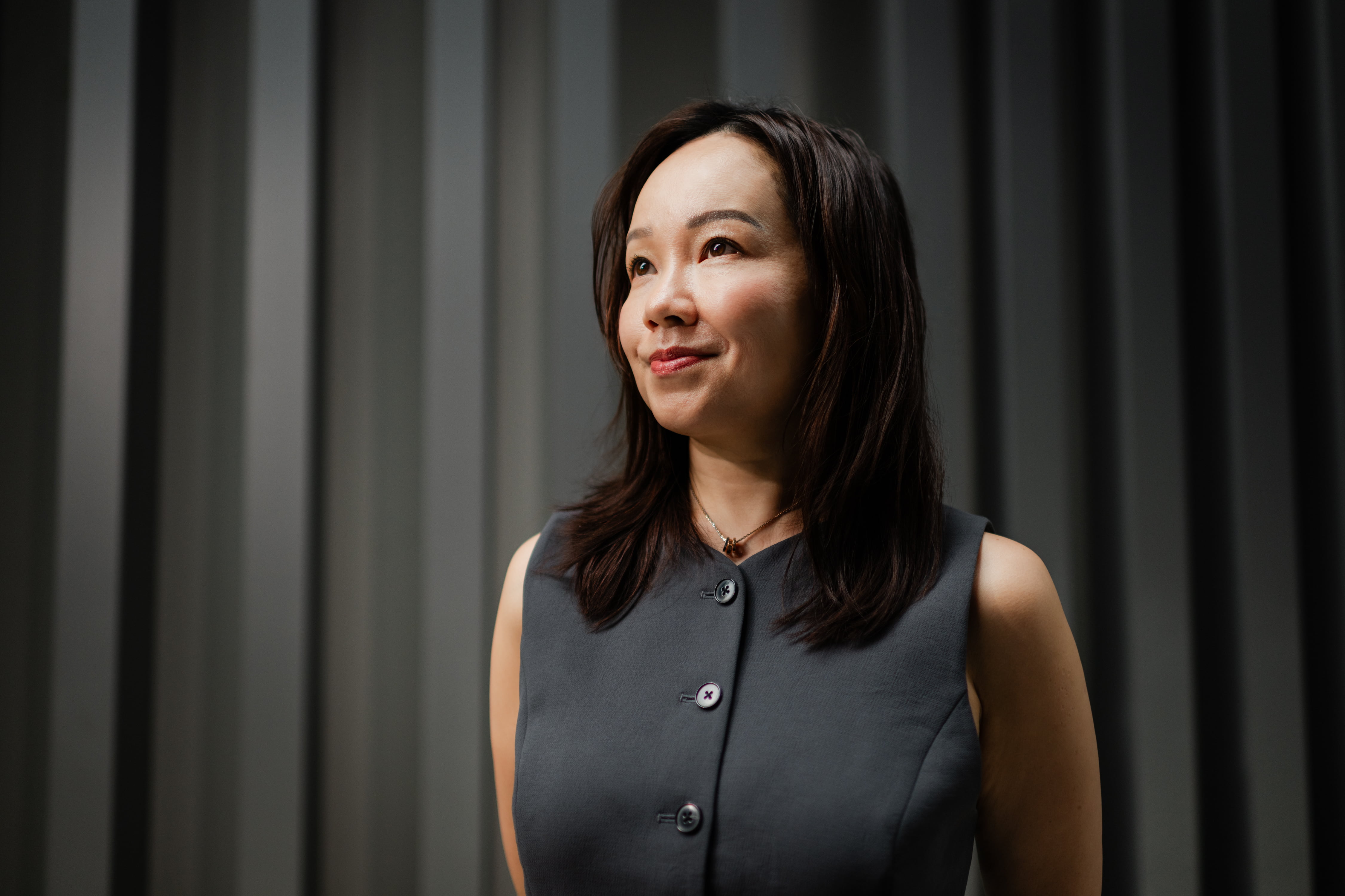 Debbie Lau posing against a grey background